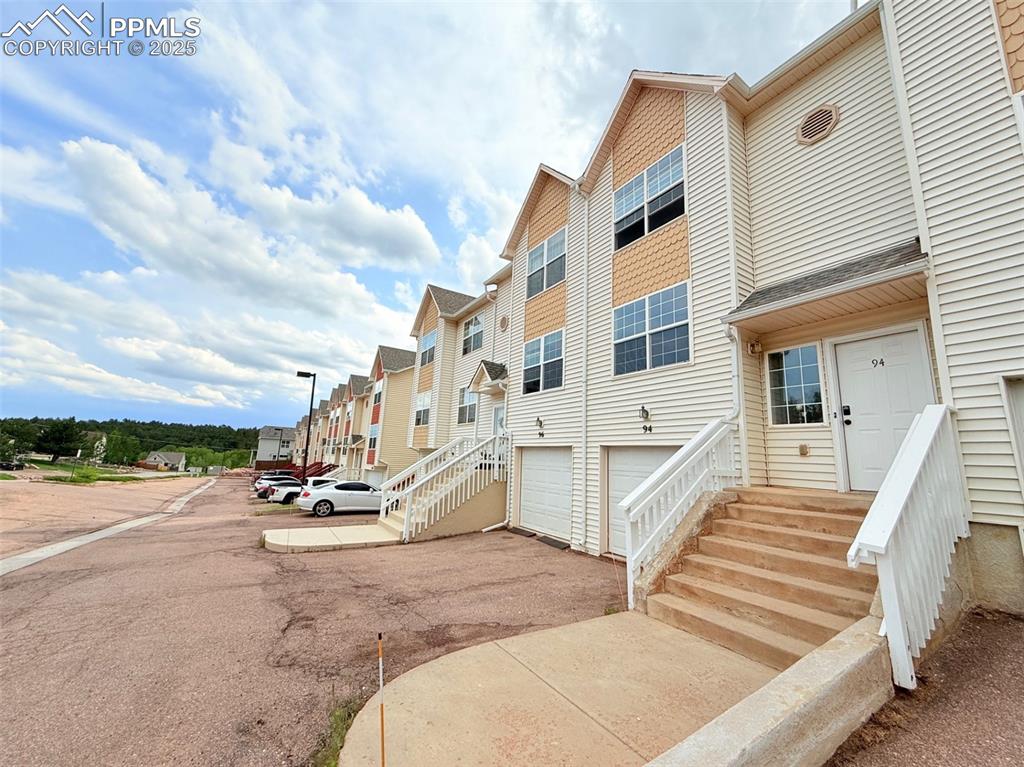 Caption: View of property featuring driveway and an attached garage