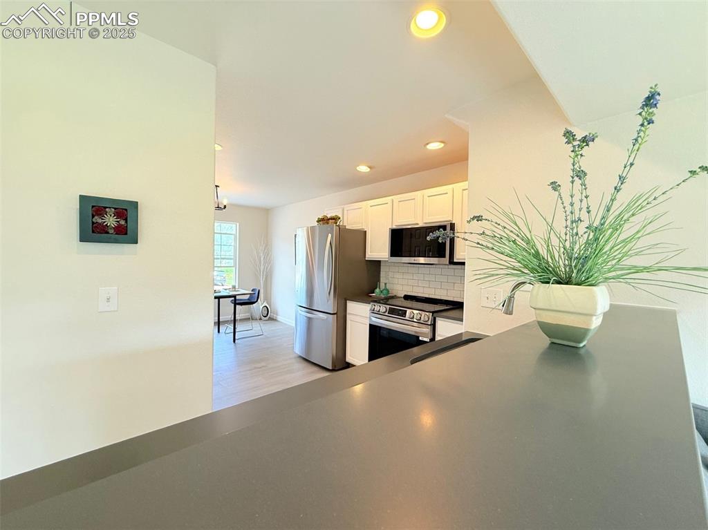 Image 10 of 44: Kitchen with appliances with stainless steel finishes, tasteful backsplash,