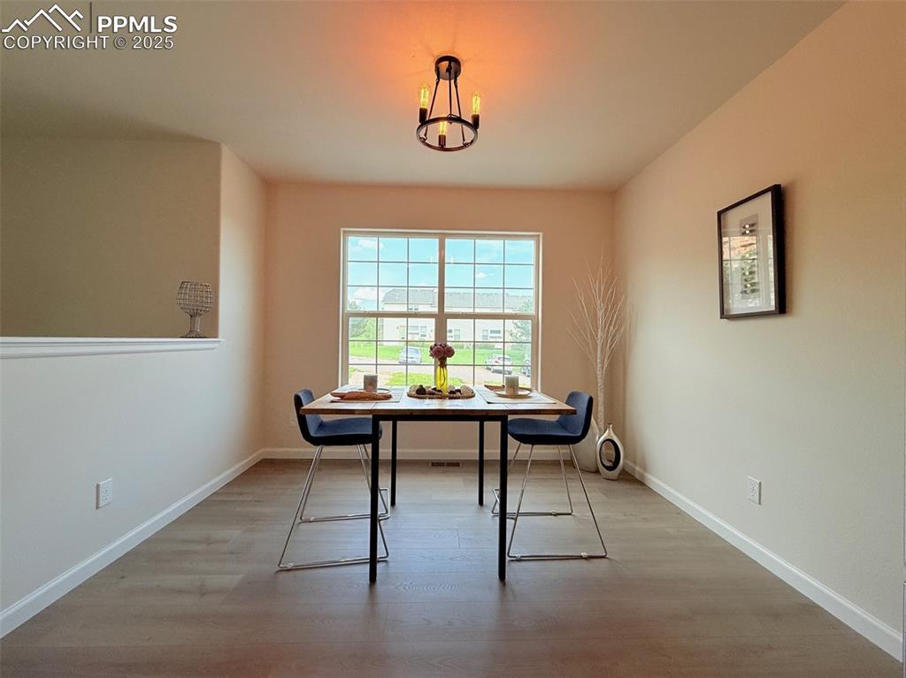 Image 13 of 44: Dining space with light wood finished floors and a chandelier