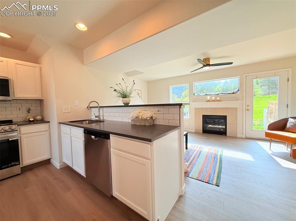 Image 14 of 44: Kitchen with open floor plan, appliances with stainless steel finishes, whi