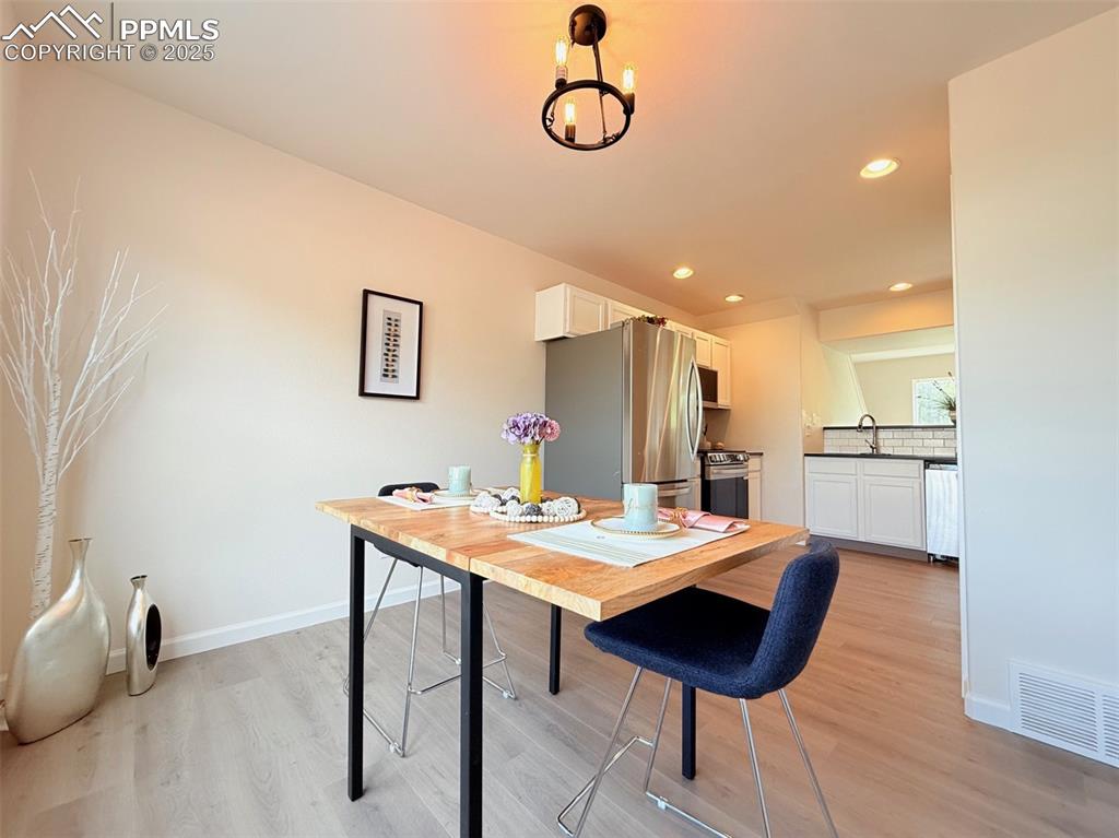 Image 16 of 44: Dining room featuring light wood-style floors and recessed lighting