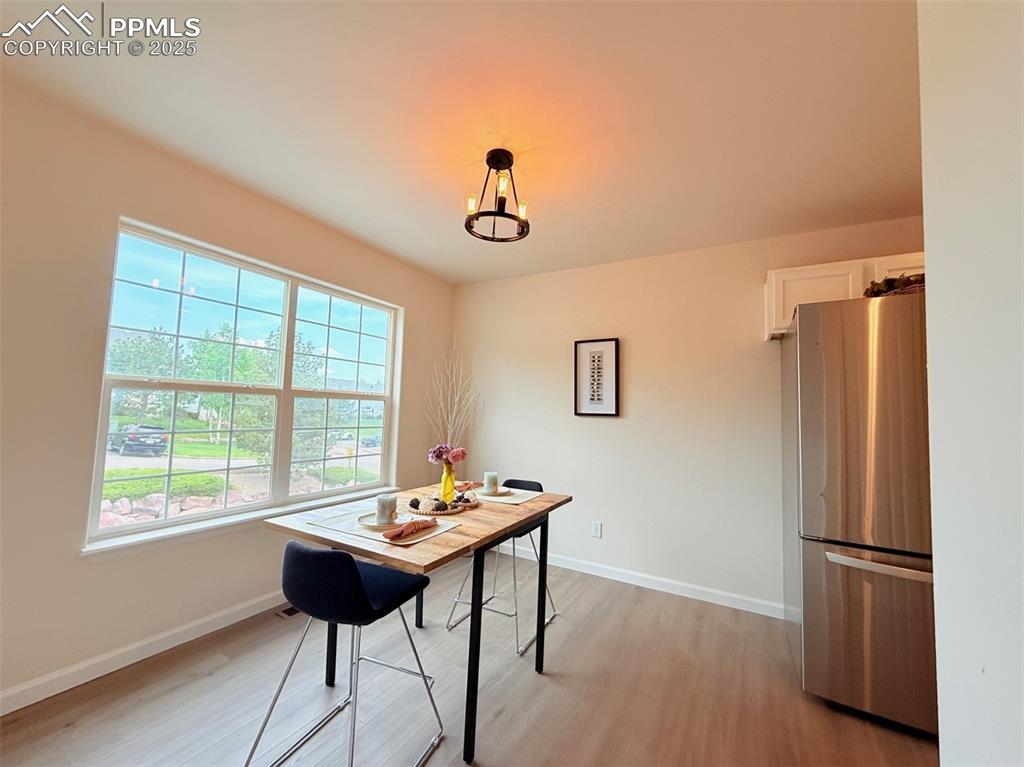 Image 17 of 44: Dining area with light wood-style floors and a chandelier