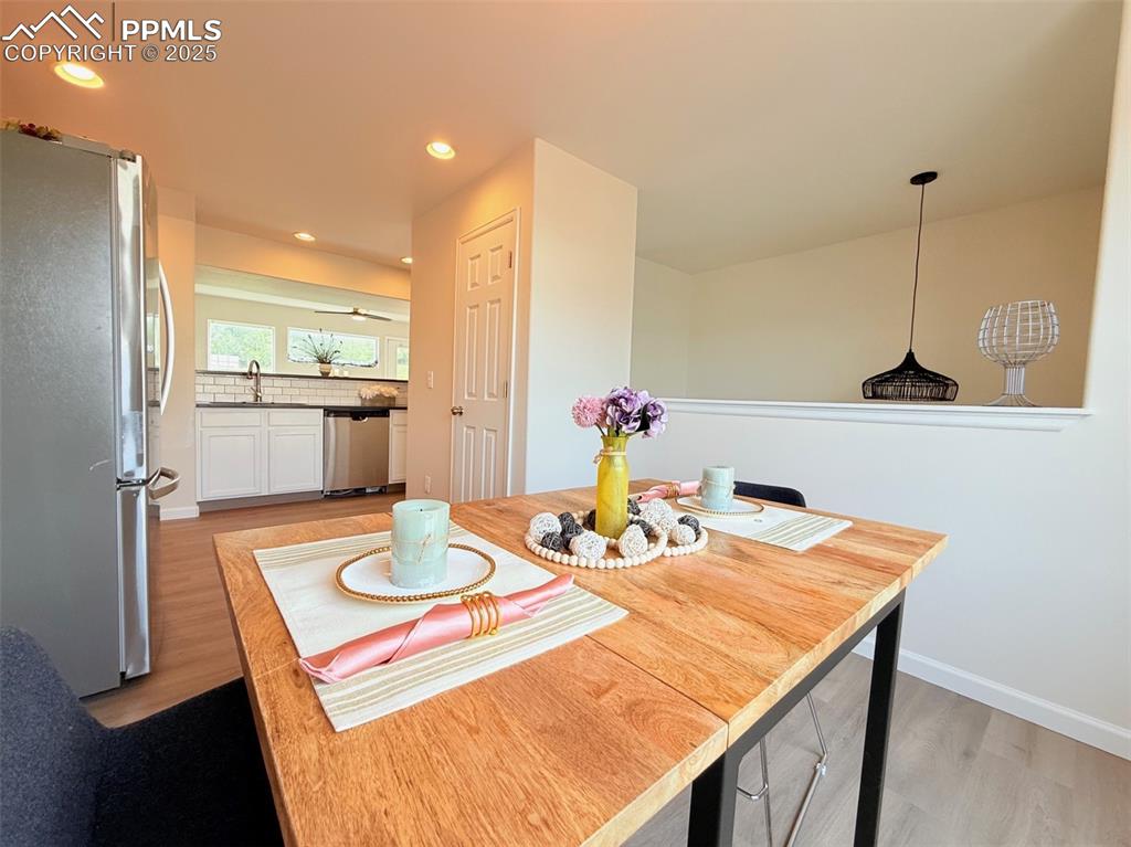 Image 19 of 44: Dining room with light wood-type flooring and recessed lighting