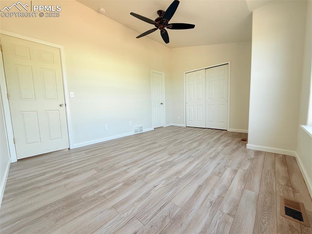 Image 24 of 44: Unfurnished bedroom with vaulted ceiling, light wood-style flooring, a ceil