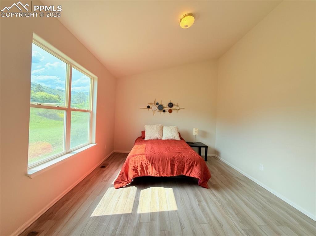 Image 28 of 44: Bedroom featuring light wood-style flooring and lofted ceiling