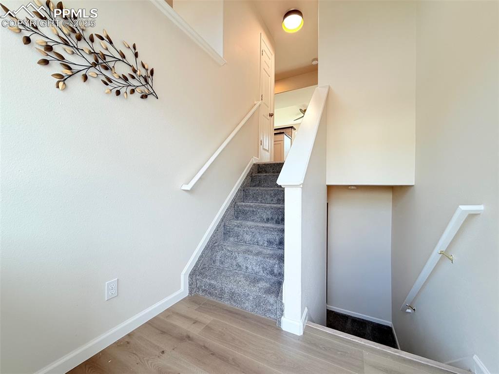Image 32 of 44: Stairs with wood finished floors and baseboards