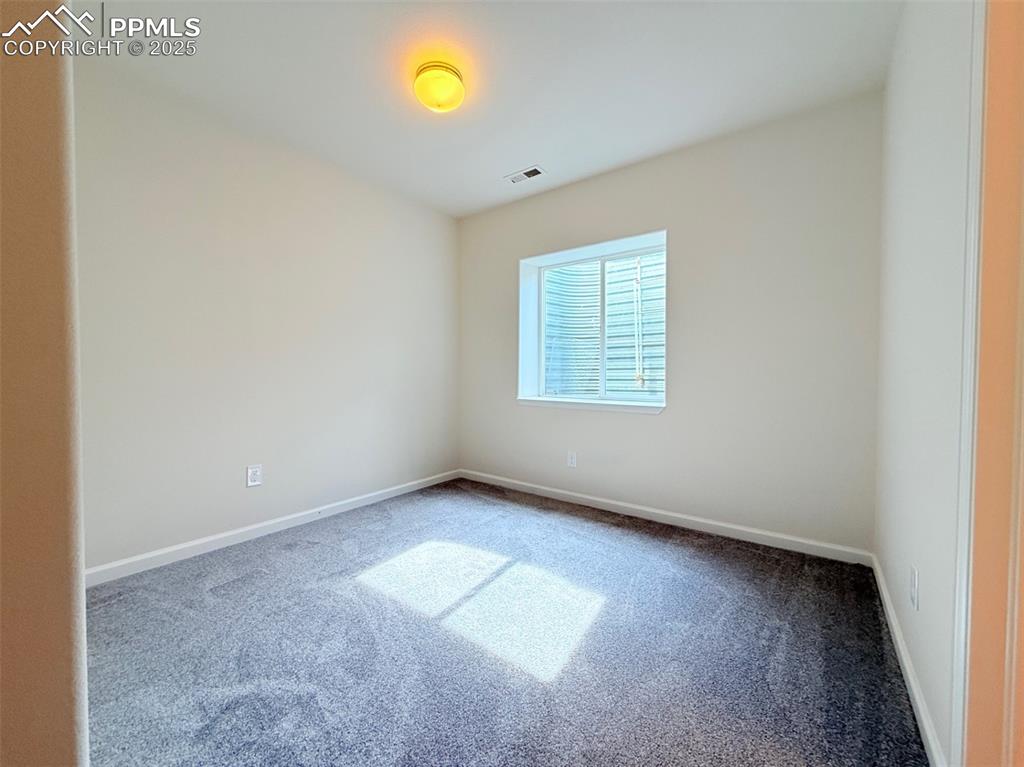 Image 33 of 44: Empty room with carpet flooring and baseboards