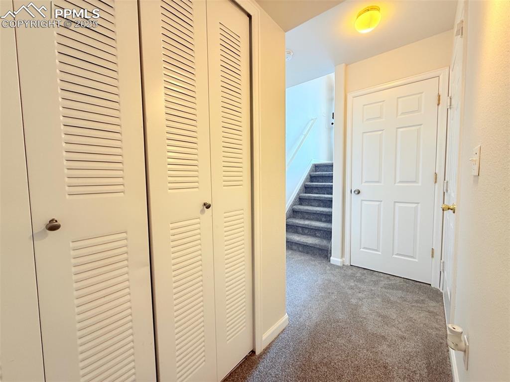 Image 37 of 44: Hall featuring dark colored carpet and stairs