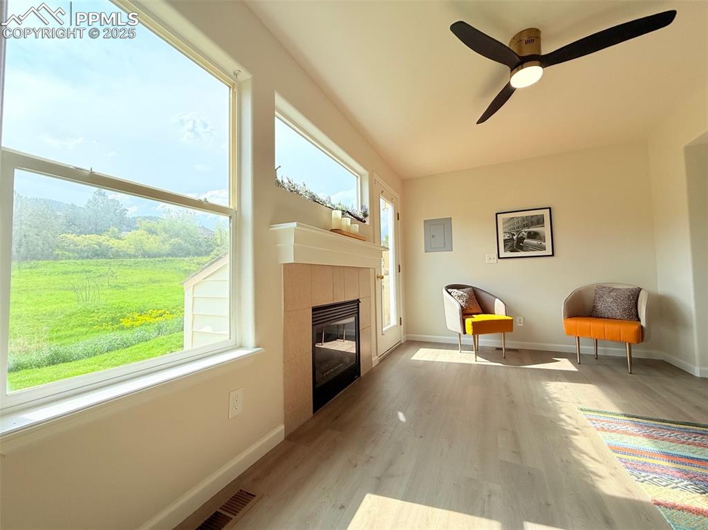 Image 8 of 44: Sitting room with light wood-style flooring, a fireplace, a ceiling fan, an