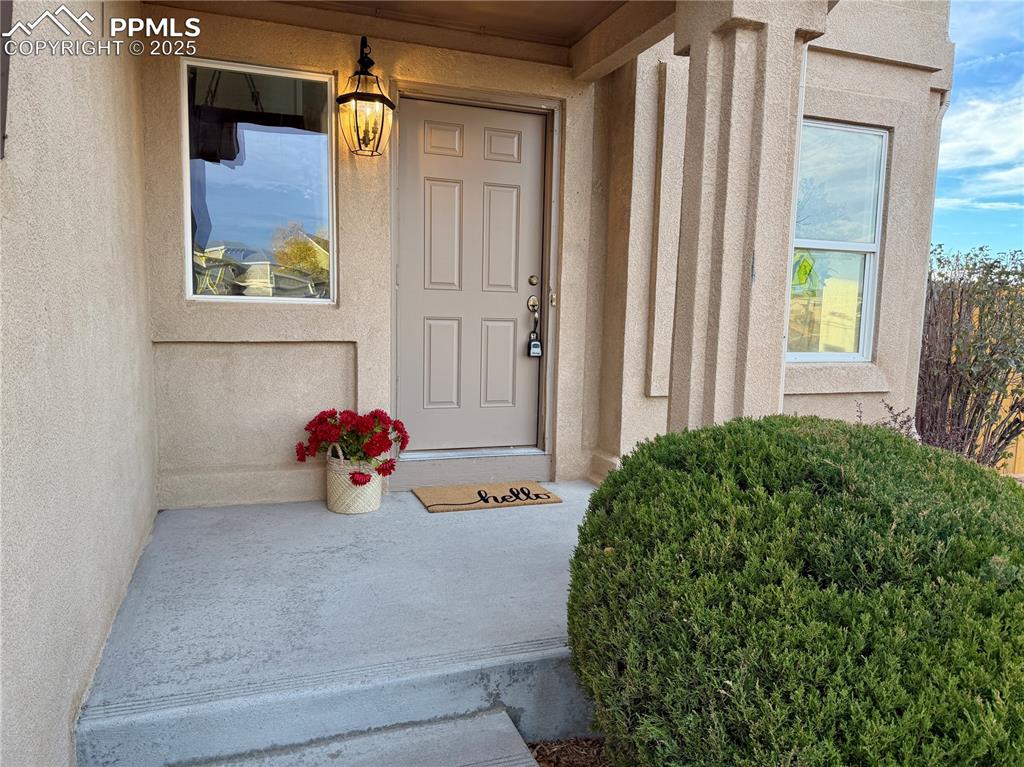 Image 2 of 38: Property entrance featuring stucco siding and covered porch