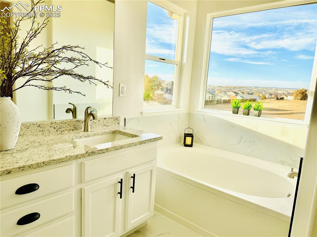 Image 21 of 38: Bathroom with vanity and a garden tub
