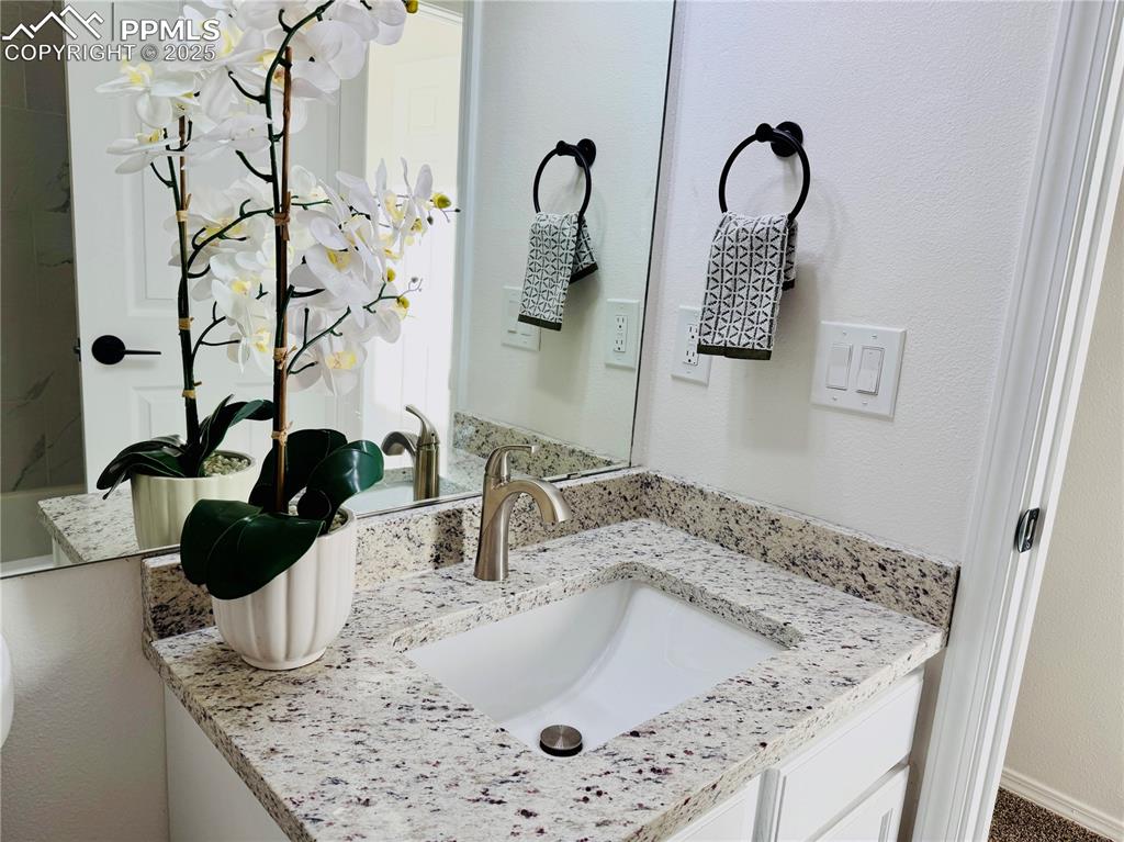 Image 27 of 38: Bathroom featuring vanity and a textured wall