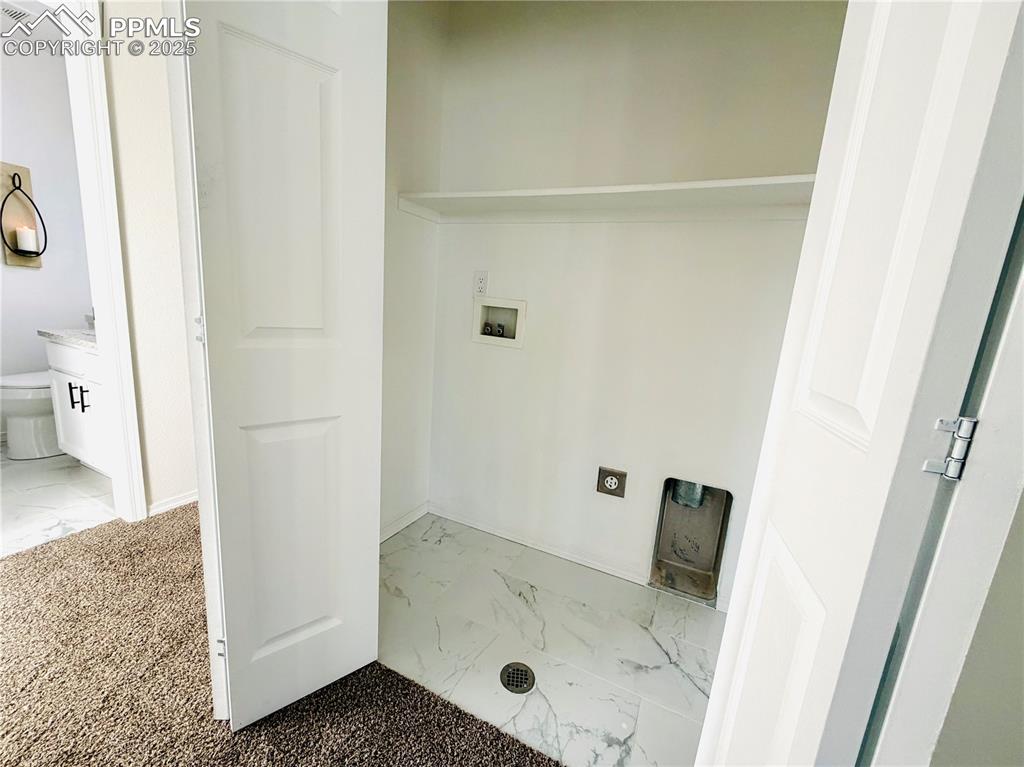 Image 33 of 38: Laundry area featuring washer hookup and light marble finish floors