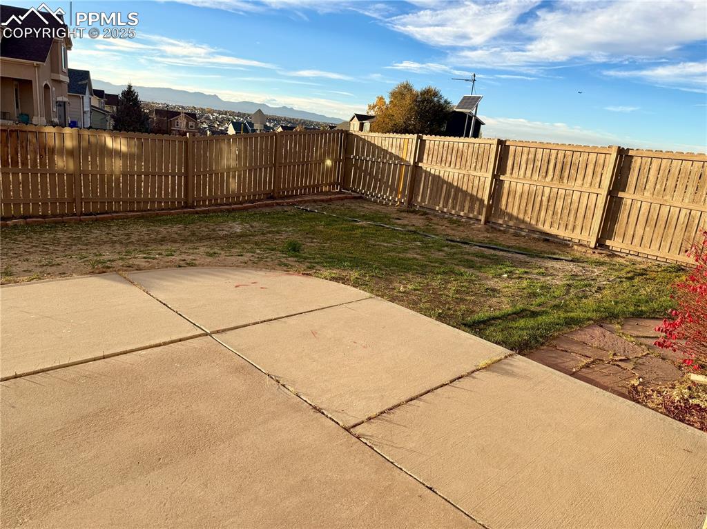 Image 37 of 38: Fenced backyard with a patio and a mountain view