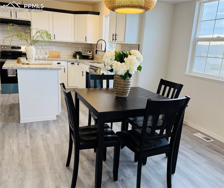 Image 8 of 38: Dining space featuring light wood-type flooring