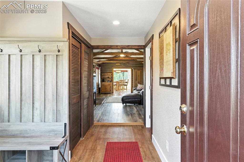 Image 14 of 43: Entrance foyer with wood finished floors, beamed ceiling, and recessed ligh