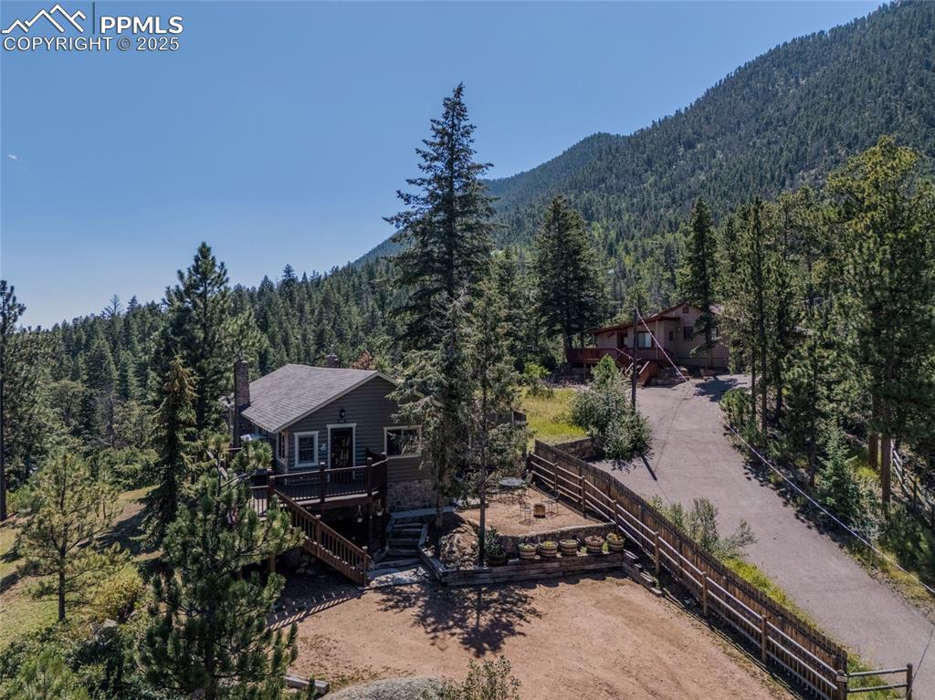 Image 2 of 43: View of subject property with a heavily wooded area and a mountain backdrop