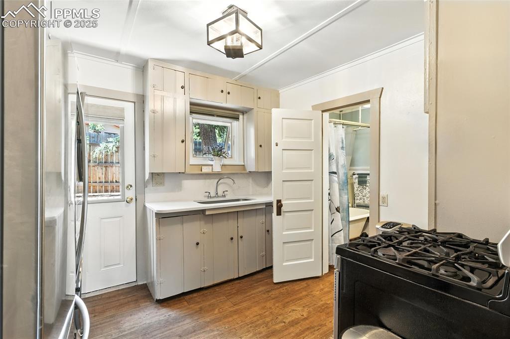 Image 25 of 43: Kitchen with freestanding refrigerator, black range with gas cooktop, light