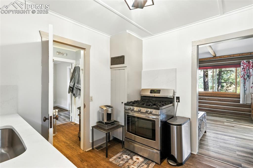 Image 26 of 43: Kitchen featuring stainless steel range with gas stovetop and dark wood-typ
