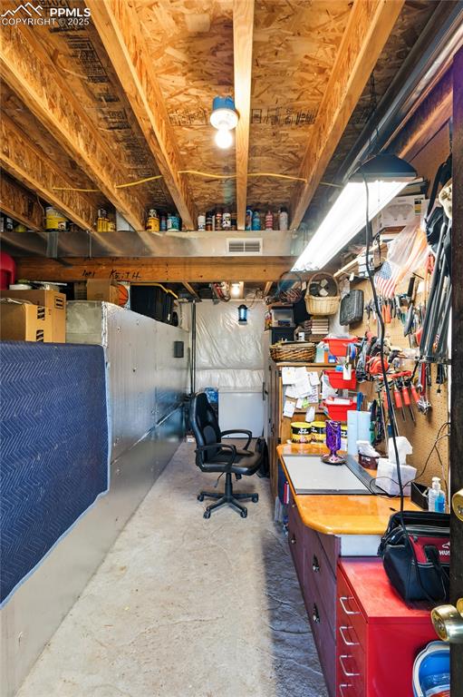 Image 37 of 43: Unfinished below grade area featuring a workshop area