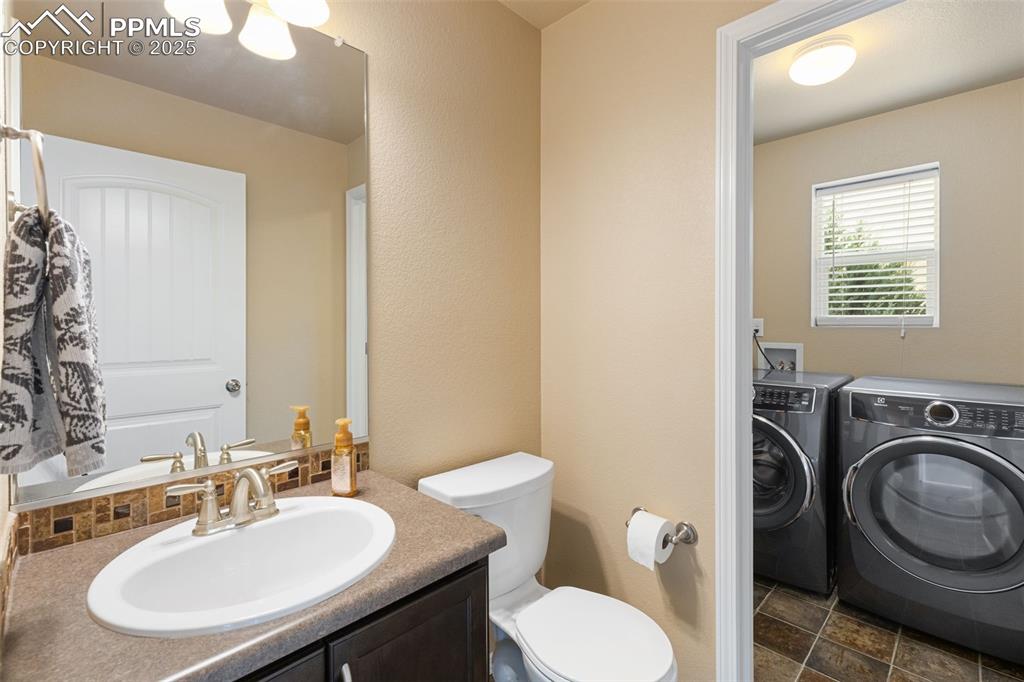 Image 18 of 50: Bathroom with independent washer and dryer, vanity, and a textured wall