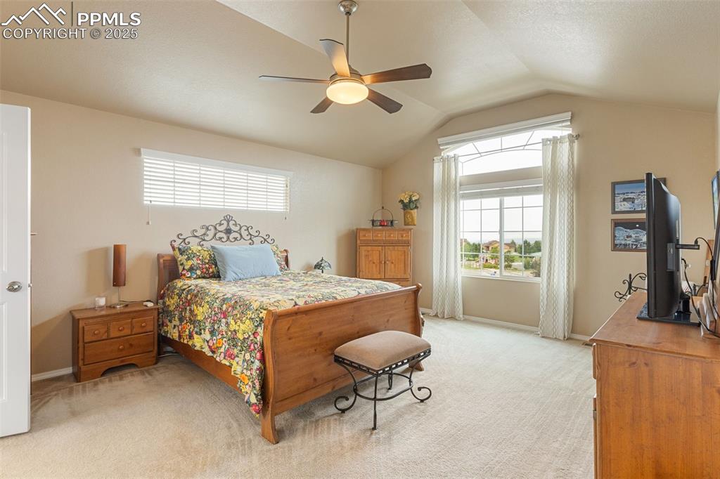 Image 19 of 50: Bedroom featuring vaulted ceiling, carpet floors, and ceiling fan
