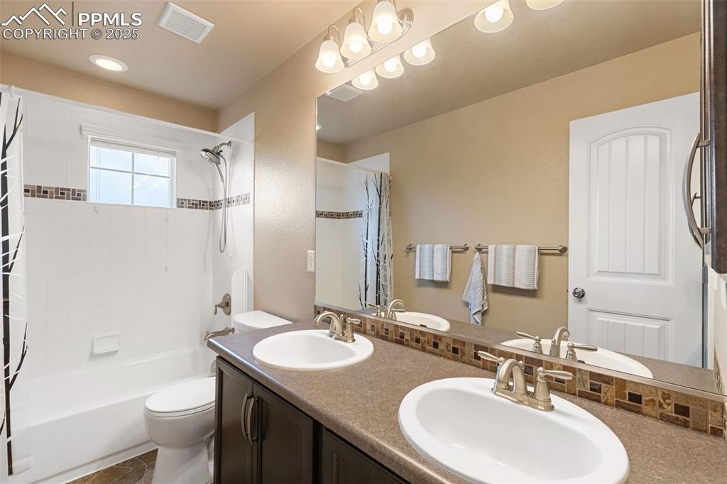 Image 31 of 50: Full bath featuring shower / tub combo with curtain and double vanity