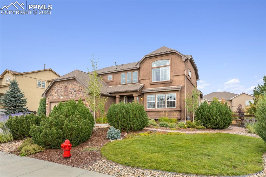 Image 41 of 50: Traditional-style house featuring a front yard, stucco siding, and roof wit