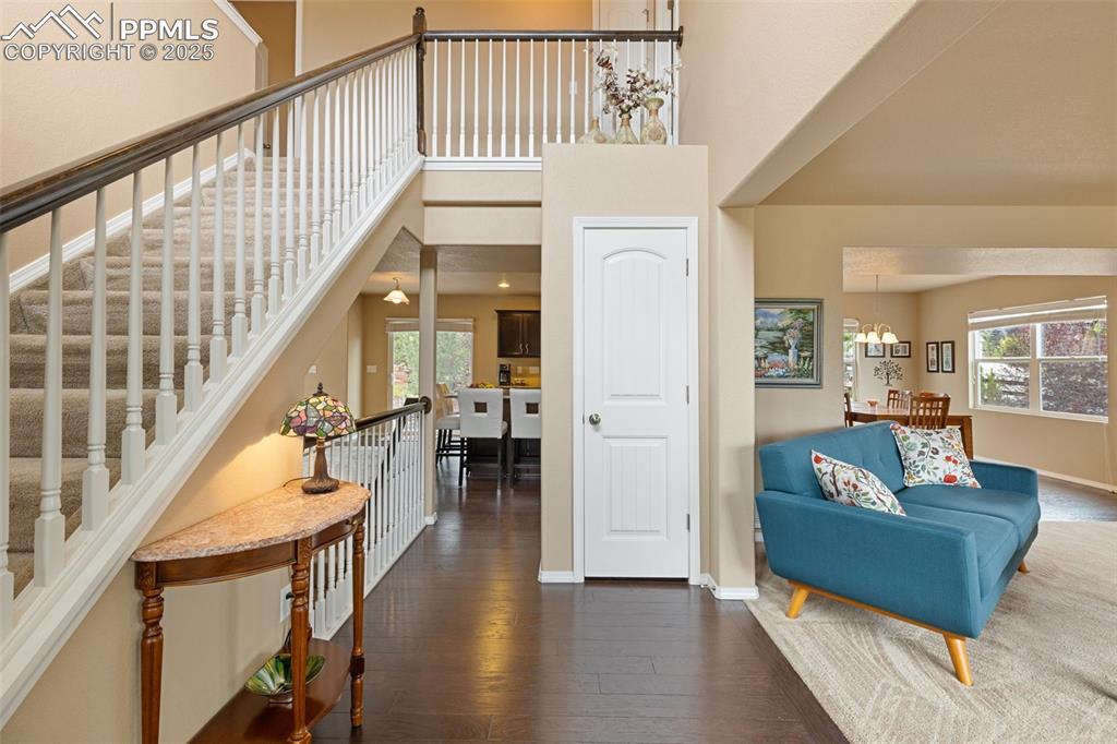 Image 6 of 50: Foyer featuring a towering ceiling, dark wood finished floors, and a chande