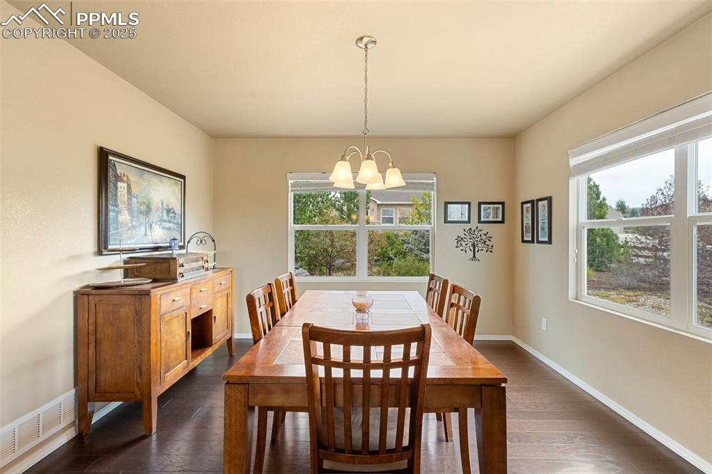 Image 9 of 50: Dining space featuring dark wood finished floors and plenty of natural ligh