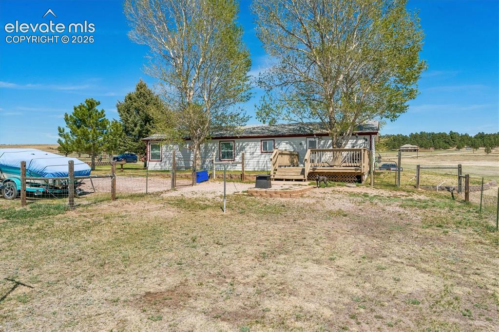 Image 21 of 34: Ranch-style residence featuring light-colored siding, a pitched roof, and a