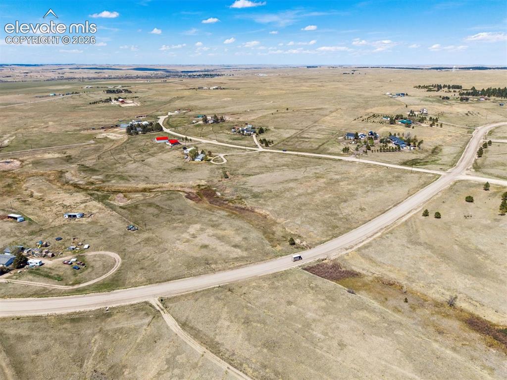 Image 29 of 34: Expansive open landscape featuring scattered residential properties, a wind