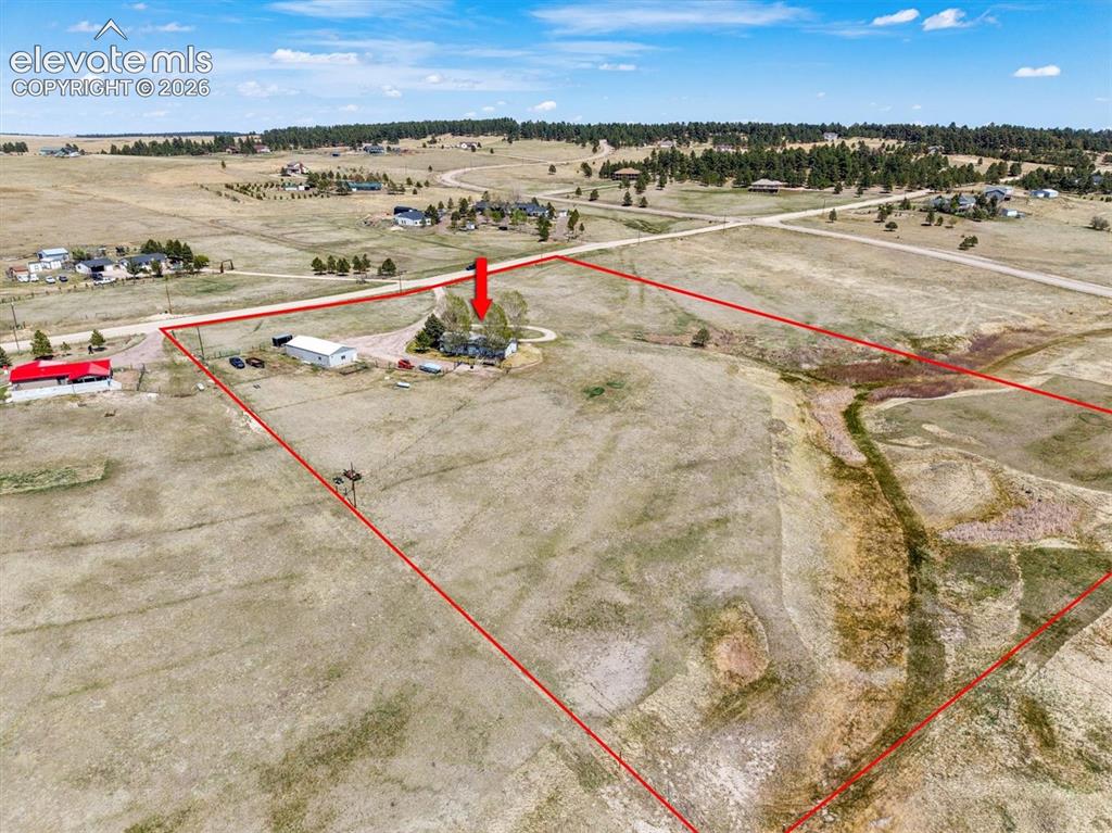 Image 32 of 40: Expansive rural property featuring a main residence, additional outbuilding