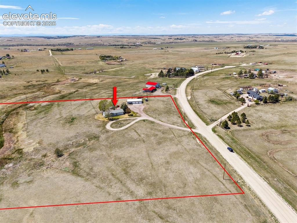 Image 33 of 40: Expansive rural property featuring a single-story residence, detached outbu