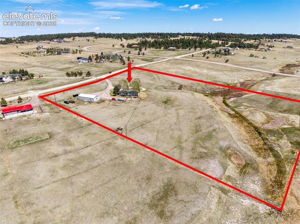 Image 36 of 40: Expansive rural property featuring a primary residence, detached outbuildin