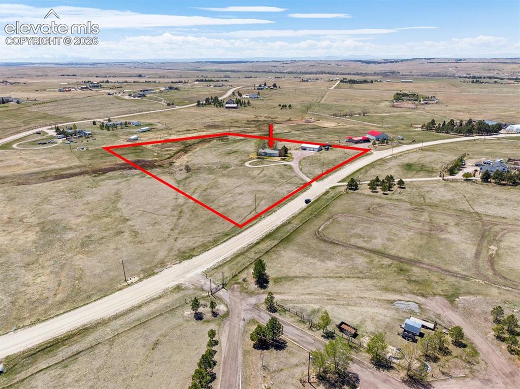 Image 37 of 40: Expansive land parcel featuring a residential structure, detached garage, a