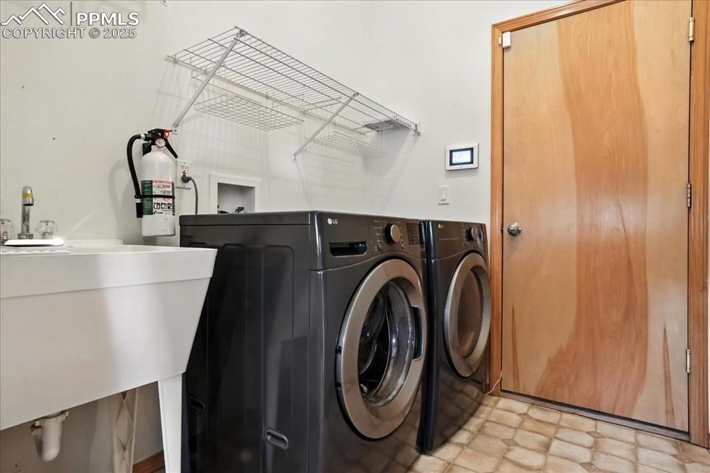 Image 15 of 50: Laundry room featuring washer and clothes dryer and light flooring