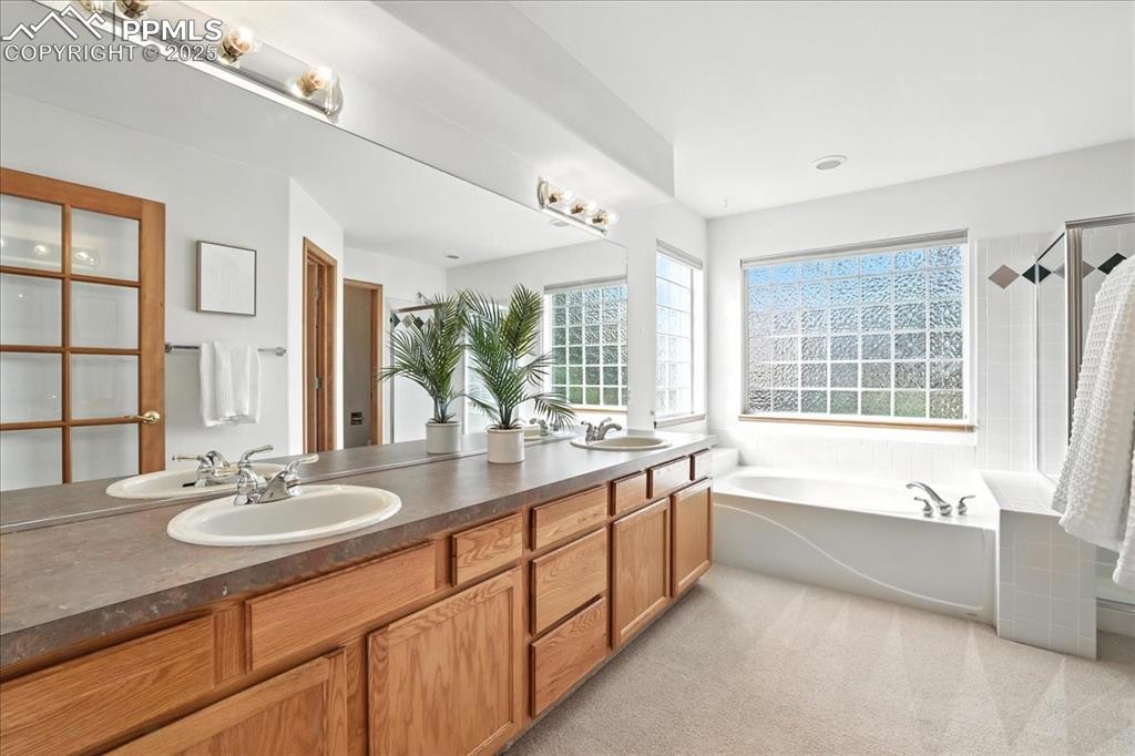 Image 18 of 50: Bathroom featuring a garden tub and double vanity