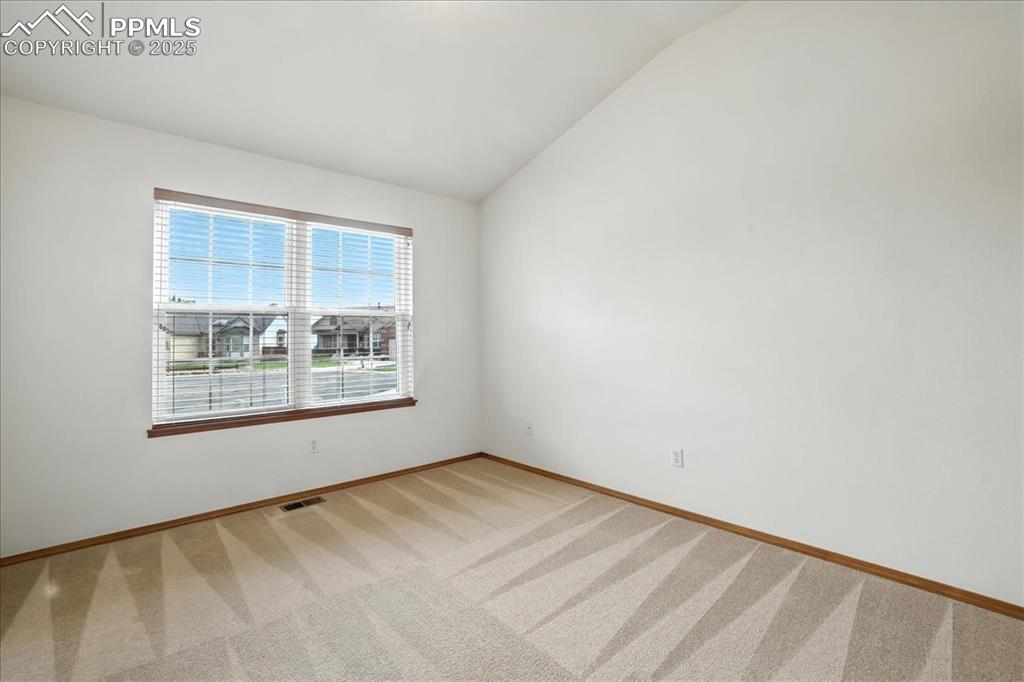 Image 21 of 50: Spare room featuring vaulted ceiling and light colored carpet