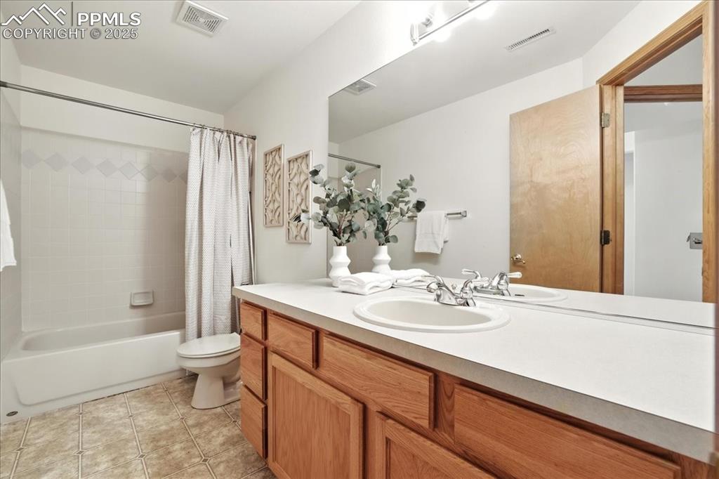 Image 30 of 50: Bathroom featuring vanity, shower / bath combination with curtain, and tile