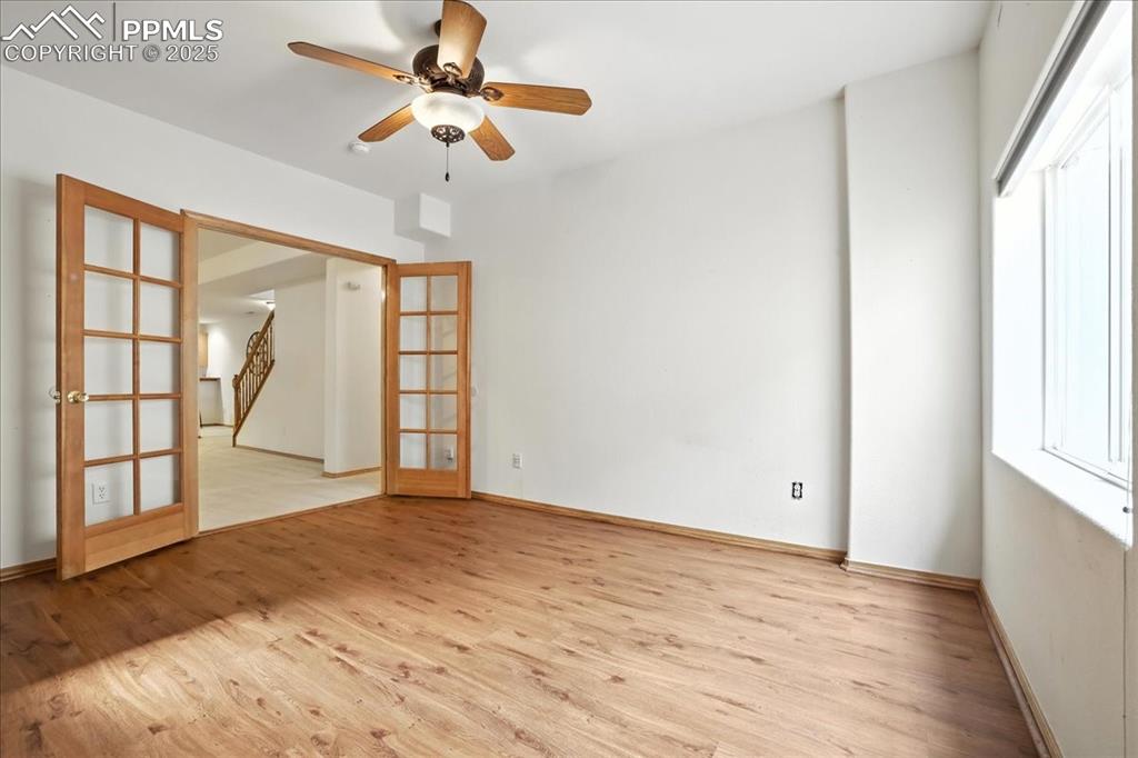 Image 31 of 50: Unfurnished room featuring french doors, wood finished floors, and a ceilin