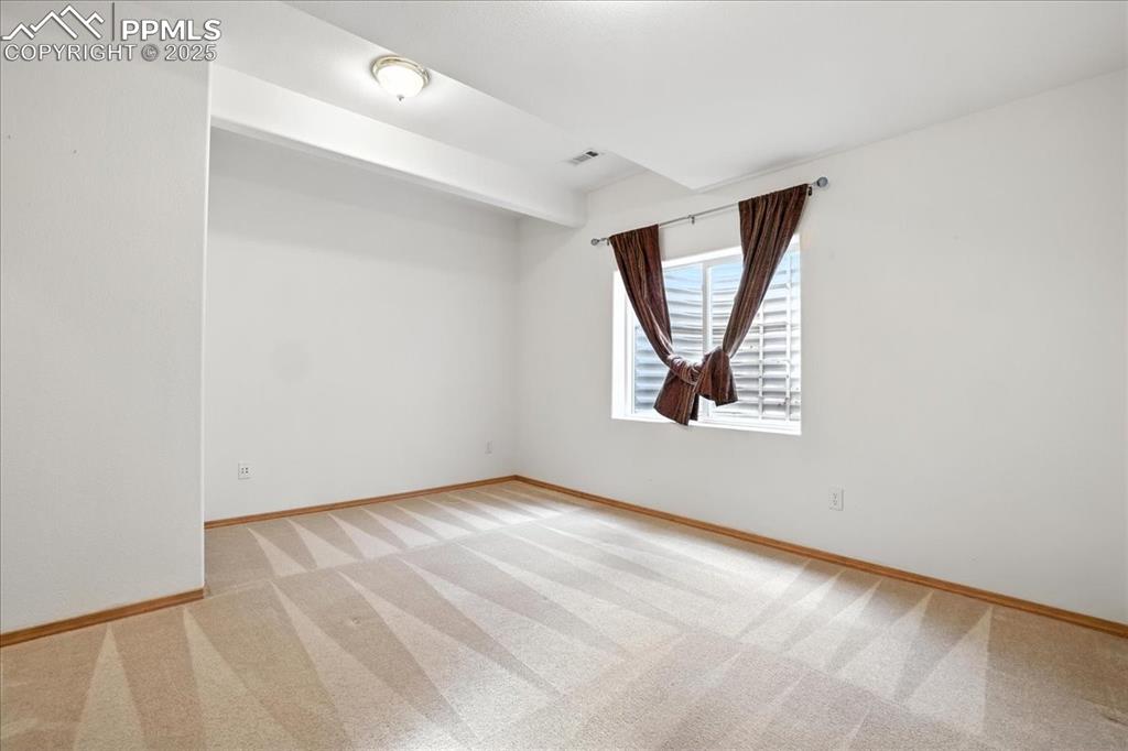 Image 34 of 50: Unfurnished room featuring carpet and beam ceiling
