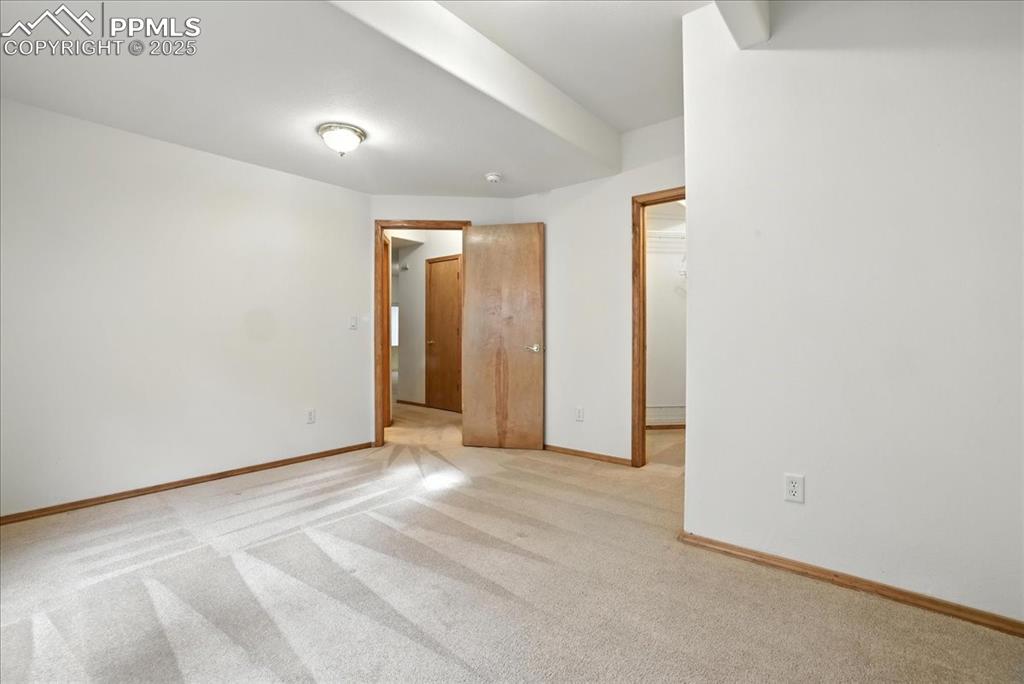 Image 36 of 50: Empty room with light colored carpet and baseboards