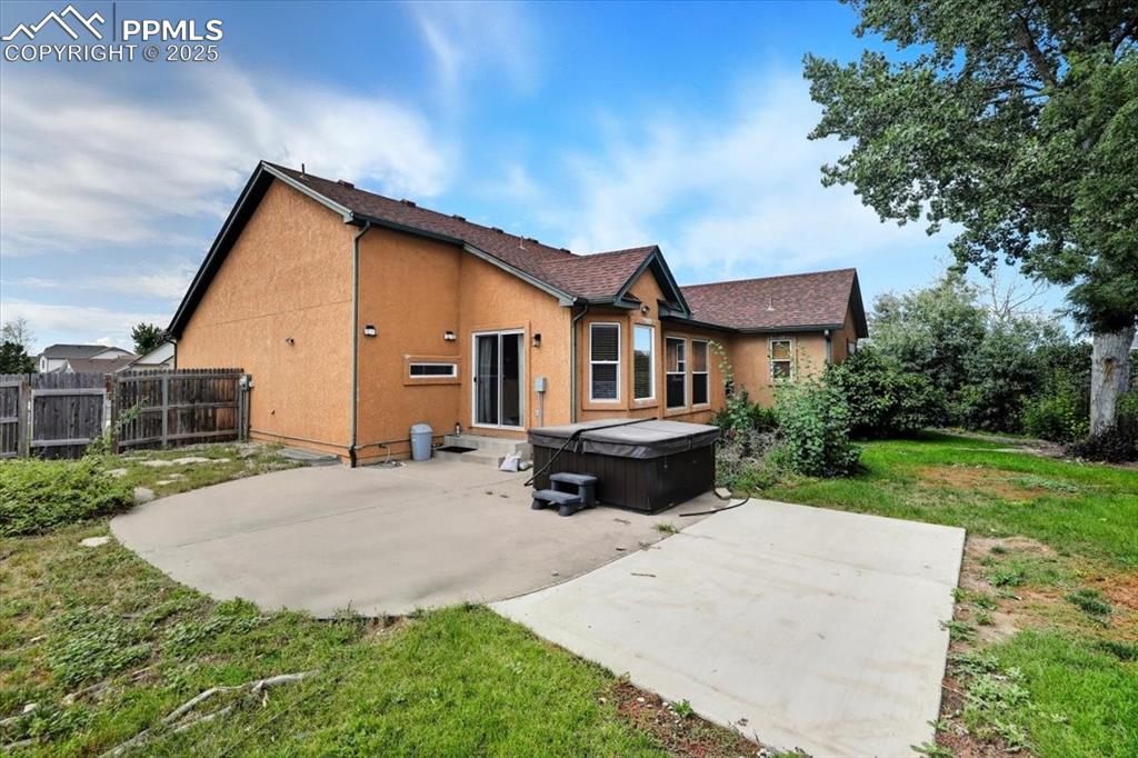 Image 46 of 50: Back of property with a patio, a hot tub, and stucco siding