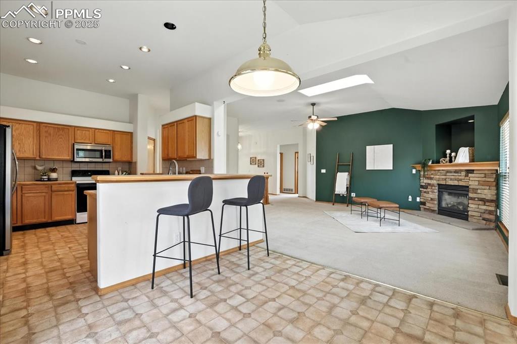 Image 9 of 50: Kitchen featuring open floor plan, vaulted ceiling, a skylight, a breakfast