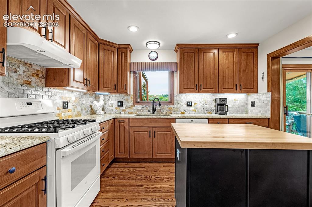 Image 10 of 42: Generous sized kitchen with gas stove, under cabinet lighting and window ov