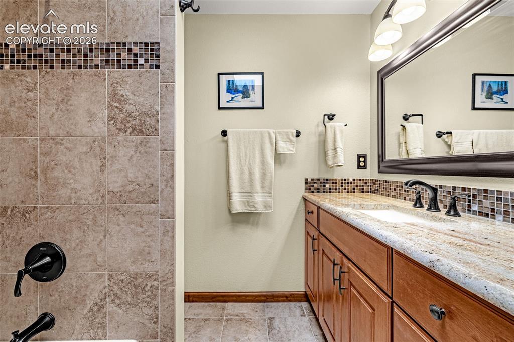 Image 18 of 42: Full bathroom with tile floors and granite counters