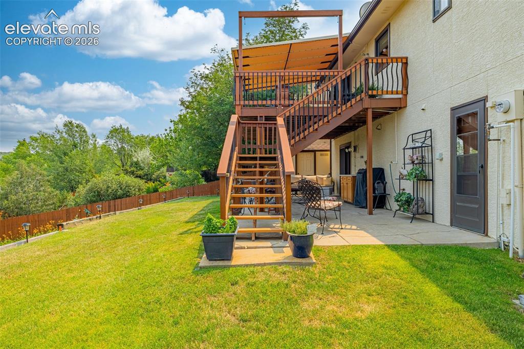 Image 28 of 42: Upper and lower patio with fully fenced backyard and access to garage
