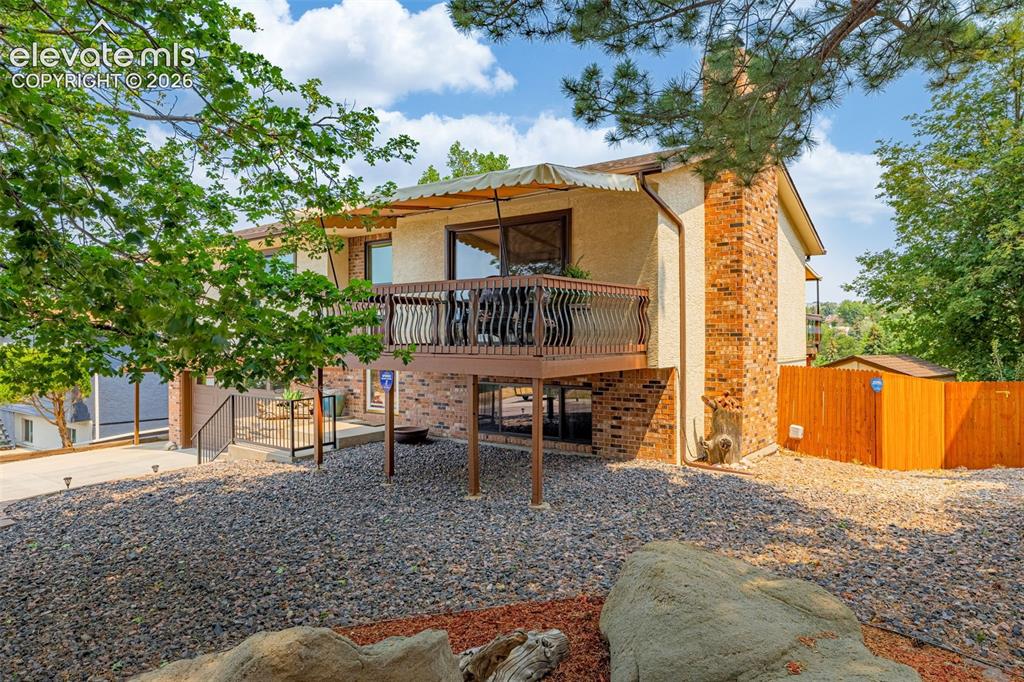 Image 3 of 42: Front yard is low maintenance xeriscaped and awning is commercial grade per