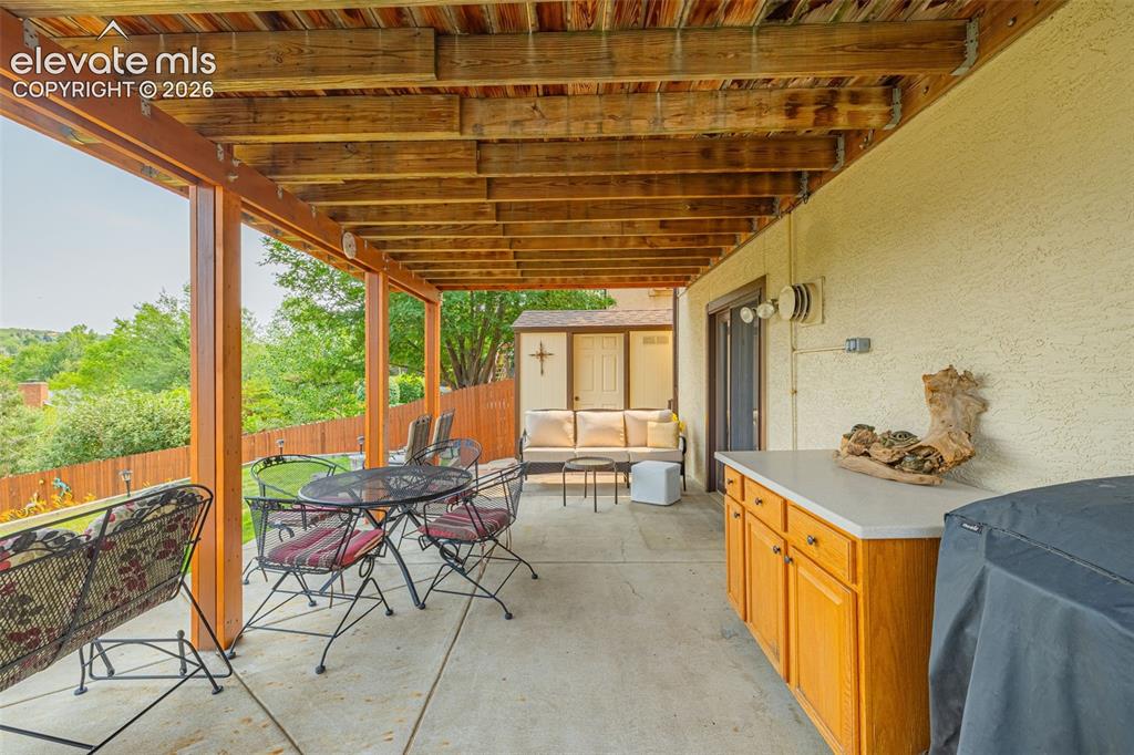 Image 30 of 42: Lower patio with one of two sheds